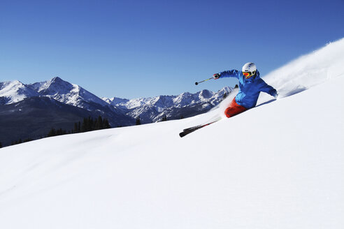 Ein sportlicher Skifahrer zieht an einem sonnigen Tag in Colorado seine Schwünge im frischen Pulverschnee. - AURF01001