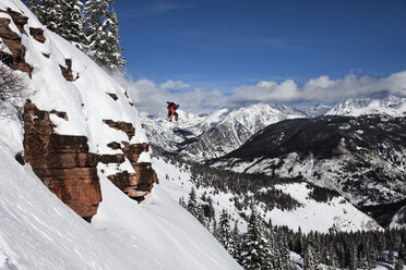Ein sportlicher Snowboarder springt an einem sonnigen Tag im Pulverschnee in Colorado von einer Klippe. - AURF01002