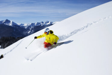 Ein sportlicher Skifahrer zieht an einem sonnigen Tag in Colorado seine Schwünge im frischen Pulverschnee. - AURF01003