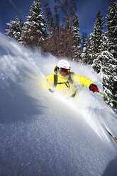 A athletic skier rips fresh powder turns on a sunny day in Colorado. - AURF01004