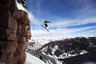 Ein sportlicher Skifahrer springt an einem sonnigen Tag in Colorado von einer Klippe im Backcountry. - AURF01010