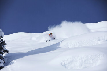 Ein sportlicher Skifahrer zieht an einem sonnigen Tag in Colorado frische Tiefschneekurven im Backcountry. - AURF01013