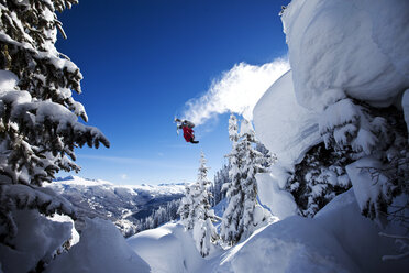 Ein sportlicher Skifahrer stürzt an einem sonnigen Tag in Colorado von einer Klippe im Backcountry. - AURF01015