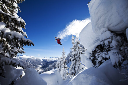 Ein sportlicher Skifahrer stürzt an einem sonnigen Tag in Colorado von einer Klippe im Backcountry. - AURF01015