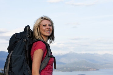 Eine sportliche Frau lächelt bei einer Rucksacktour in Idaho. - AURF01021