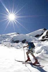 Ein Skitourengeher benutzt Steigfelle an seinen Skiern, um an einem schönen Augusttag einen Gletscher auf dem 10.781 Fuß hohen Mt. Baker in der Mt. Baker Wildeerness, Washington, zu besteigen. - AURF01025