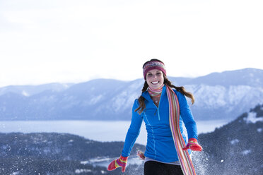 Eine sportliche junge Frau lacht beim Schneeschuhwandern in Idaho. - AURF01032