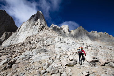 A female hiker scrambles up the mountaineer's route of Mount Whitney, California. - AURF01064