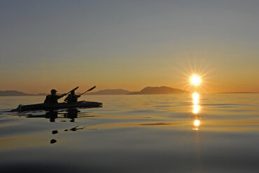 Ein Vater und seine Tochter paddeln bei Sonnenuntergang in der Samish Bay bei Bow, Washington. - AURF01070