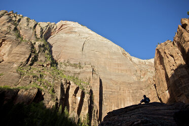 A hiker rests on a rock in Zion National Park. - AURF01096