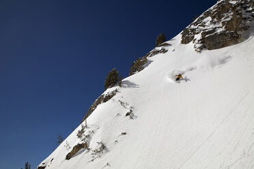 A male snowboarder rides a steep back country couloir called the Sliver Couloir, in the Grand Teton National Park of Wyoming. - AURF01110