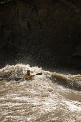 Ein Kajakfahrer stößt während einer Rafting-Tour in Westchina auf großes Wildwasser. - AURF01118