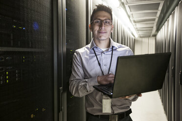 Ein hispanischer Techniker führt Diagnosetests an Computerservern in einer großen Serverfarm durch. - MINF08963