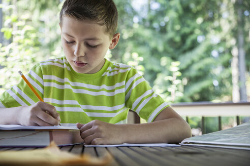 Young boy at home doing homework. - MINF08972