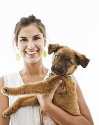 Portrait of Hispanic woman at home with her mixed breed puppy. - MINF08984