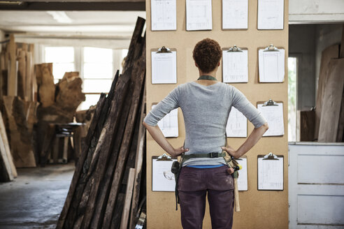 Eine Fabrikarbeiterin prüft das Projektinventar in einer Holzverarbeitungsfabrik. - MINF09060