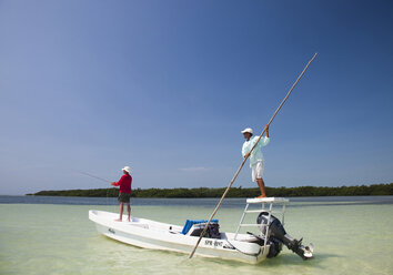 A man fly fishes in the clear waters off the coast of Belize. - AURF01137