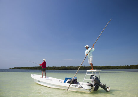 Ein Mann angelt mit der Fliege in den klaren Gewässern vor der Küste von Belize. - AURF01137
