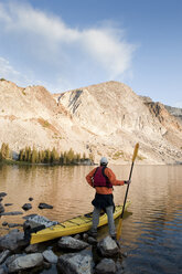 A man sea kayaking on Lake Marie in the Medicine Bow Mountains near Centennial, Wyoming. - AURF01157