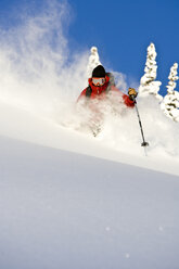A man skiing deep powder on a sunny day. - AURF01168
