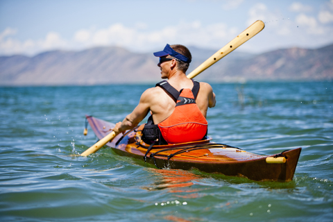 Ein Mann paddelt in einem Holzkajak auf dem Bear Lake, Utah., lizenzfreies Stockfoto