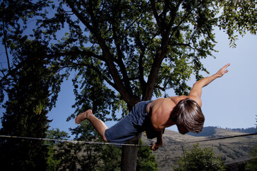 Ein professioneller Slackliner spielt auf der Slackline auf dem Campus einer Universität in Missoula, Montana, herum. - AURF01187