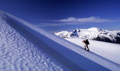 A ski mountaineer skis up a snow slope near Whistler, British Columbia during a classic 3 day ski traverse of the Spearhead Range. - AURF01199