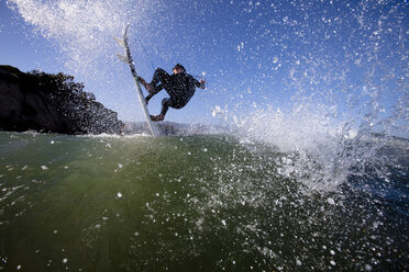 Ein geübter männlicher Surfer macht einen Luftsprung. - AURF01206