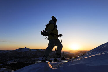 A silhouette of a skier watching sunrise in the Sierra Nevada near Lake Tahoe, California. - AURF01209