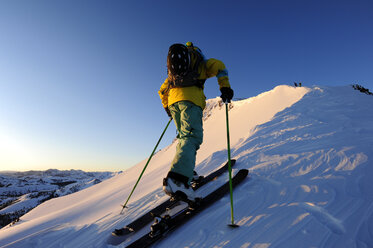 A skier skinning up a snow covered slope at sunrise in the Sierra Nevada near Lake Tahoe, California. - AURF01210