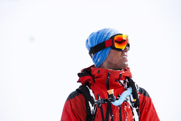 Ein Snowboarder lächelt, nachdem er frische Powder-Kurven einen Berg in Colorado hinuntergerast ist. - AURF01213