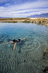 Eine Frau schwimmt in Cuatro Cicnigas, Mexiko. - AURF01225