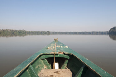 A wooden canoe made of Eucalyptus tree floats in the amazon river and connecting tributary rivers in the rainforest. - AURF01226