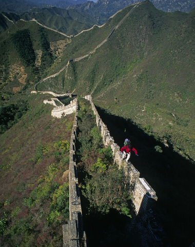 A traveler explores a remote section of The Great Wall of China. stock photo