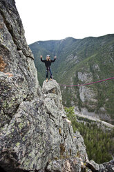 Ein junger Mann hält beim Klettern die Hände in die Luft, nachdem er einen Turm in Montana erklommen hat. - AURF01255