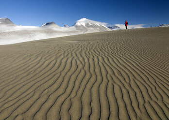 Ein Forscher hält inne, um die Schönheit einer Sanddüne im Wright Valley in den Dry Valleys der Antarktis zu bewundern - AURF01281