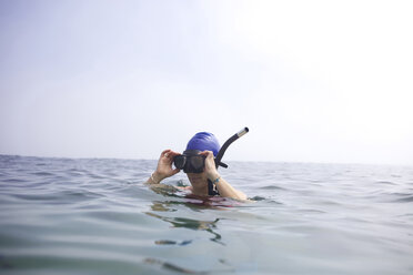Female swimmer takes snorkel off after swimming the Cove in La Jolla. - AURF01306