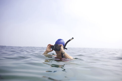 Eine Schwimmerin nimmt nach dem Schwimmen in der Cove in La Jolla den Schnorchel ab. - AURF01306