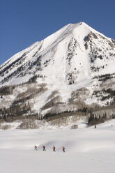 Four skiers alpine tour in the distance in Colorado. - AURF01321