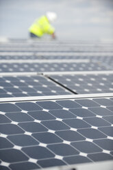 Techniker für grüne Energie justiert Fotovoltaikmodule auf einem Dach - AURF01330