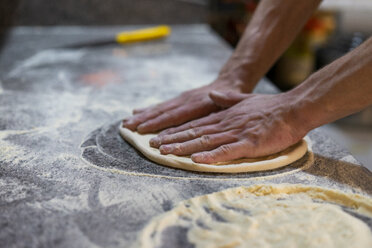 Nahaufnahme eines Pizzabäckers bei der Zubereitung von Pizzateig in der Küche - AFVF01437