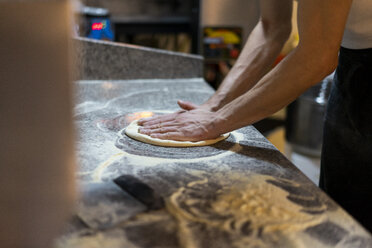 Nahaufnahme eines Pizzabäckers bei der Zubereitung von Pizzateig in der Küche - AFVF01450