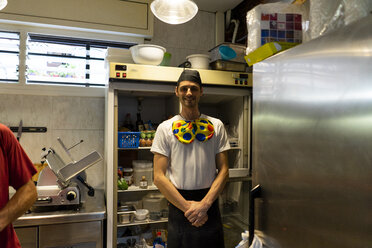 Porträt eines lustigen Pizzabäckers mit Clownsfliege in der Küche - AFVF01460