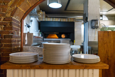 Stacks of plates on the counter in a pizzeria - AFVF01467