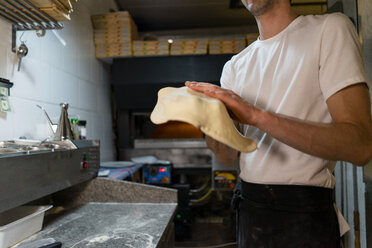 Nahaufnahme eines Pizzabäckers bei der Zubereitung von Pizzateig in der Küche - AFVF01468