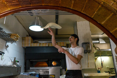 Pizzabäcker bereitet Pizza in der Küche vor und wirft den Teig in die Luft - AFVF01469
