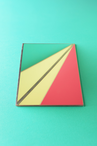 Dreiecksförmige Spiegel auf grünem Hintergrund, lizenzfreies Stockfoto