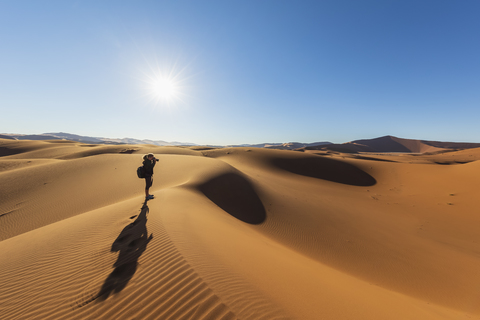 Afrika, Namibia, Namib-Wüste, Naukluft-Nationalpark, Fotografin auf Sanddüne gegen die Sonne, lizenzfreies Stockfoto