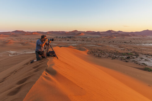 Afrika, Namibia, Namib-Wüste, Naukluft-Nationalpark, Fotografin auf Sanddüne bei Sonnenaufgang - FOF10102