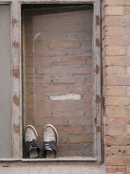 Pair of shoes in a bricked window - JMF00417